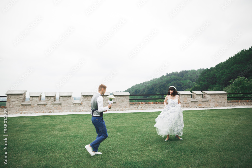 Romantic wedding moment, bride running from groom in a park Romantic wedding moment, bride running from groom in a park