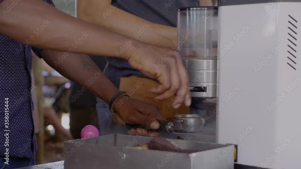 African barista cleaning coffe machine and making freshly brewed coffee at a street food market in Hermanus in South Africa. African barista cleaning coffe machine and making freshly brewed coffee at a street food market in Hermanus in South Africa.
