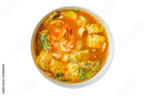 Acacia omelet with fresh shrimp in vegetable sour soup isolated on white background. Deep fried cha om leaves sour curry. Kang som cha om koong spicy of Asian traditional style. Thai food. Top view