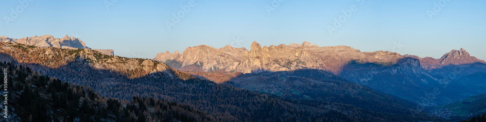 Early morning autumn alpine Dolomites mountain scene. Peaceful panoramic view from Valparola Pass, Belluno, Italy. Picturesque traveling, seasonal, and nature beauty concept scene.