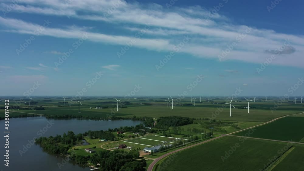 A wind farm with a couple of dozen windmills fading into the distance as the camera pulls away. A wind farm with a couple of dozen windmills fading into the distance as the camera pulls away.