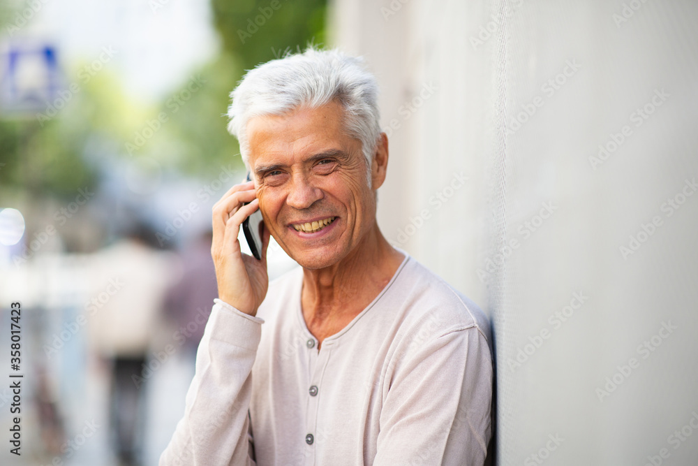 Close up handsome older man talking with phone outside Close up handsome older man talking with phone outside