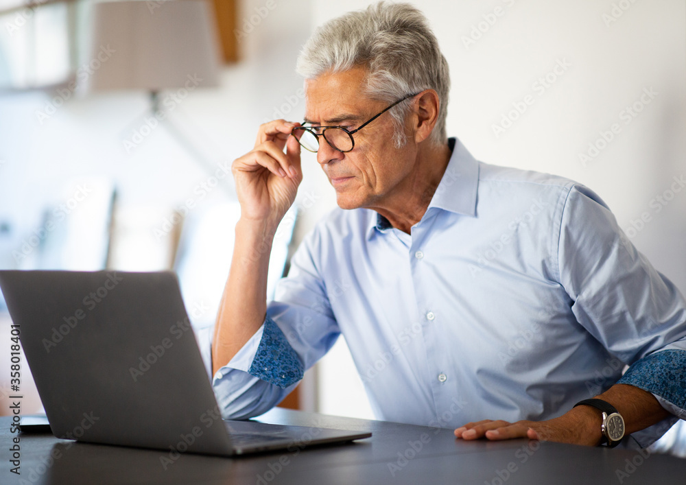 Close up businessman sitting in office looking at laptop computer Close up businessman sitting in office looking at laptop computer