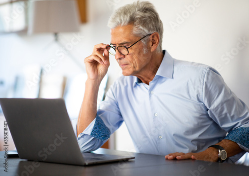 Close up businessman sitting in office looking at laptop computer