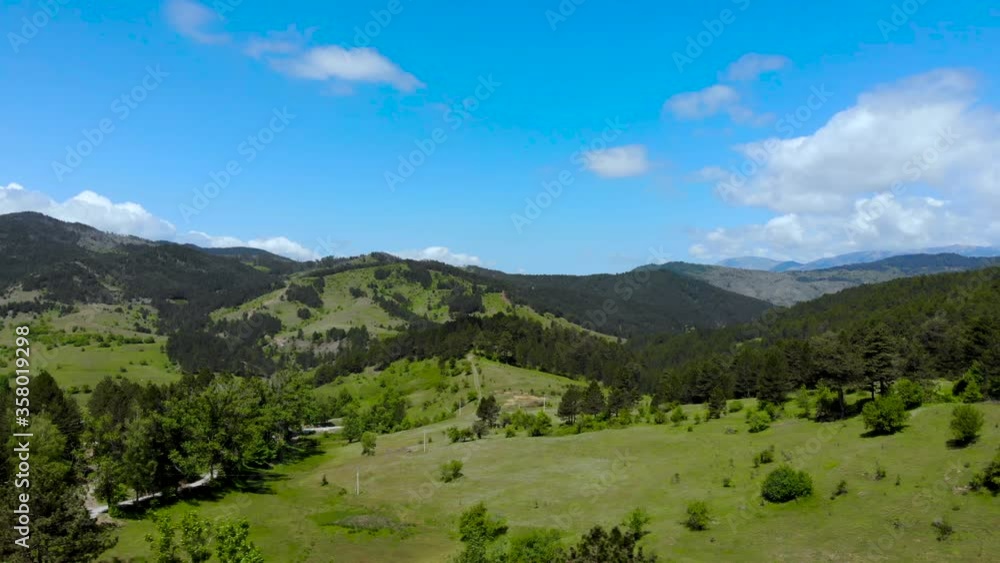 Paradise landscape with green meadows and pine trees forest on mountains in a spring day with cloudy sky Paradise landscape with green meadows and pine trees forest on mountains in a spring day with cloudy sky