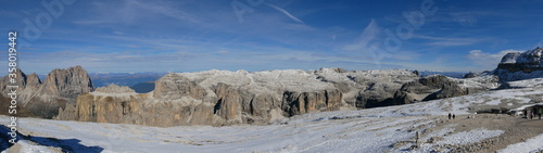Panoramafoto vom Sass Pordoi in Richtung Langkofel und Sellastock und Schneefeld im Vordergrund bei strahlend blauem Himmel