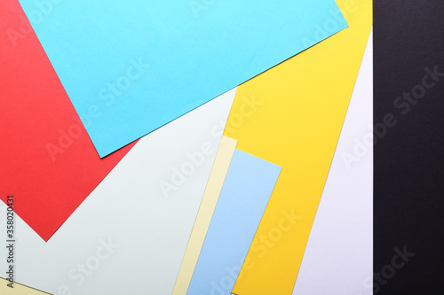 Multicolored paper background. Paper sheets of rainbow colors close-up. Geometric multitask background. Place for text. View from above.Close-up Of Multi Colored Paper. 