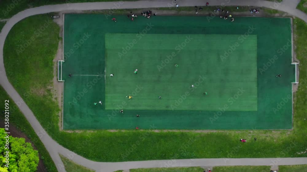 Aerial view of men playing football on a public city soccer field Aerial view of men playing football on a public city soccer field