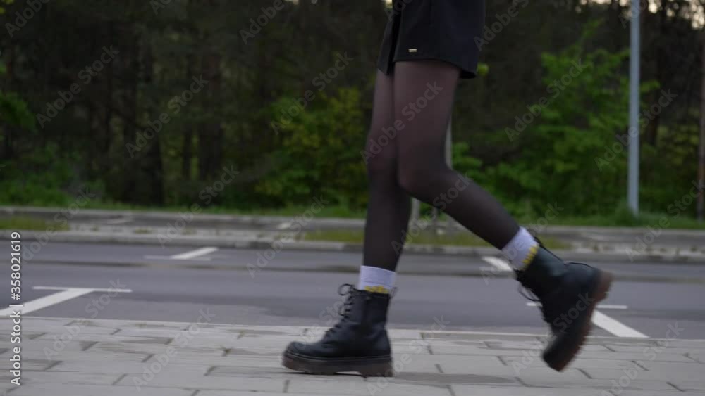 custom made wallpaper toronto digitalSlow motion shot of woman legs. Close up shot of female walking side, she wears black boots. Parking lot and trees in background.