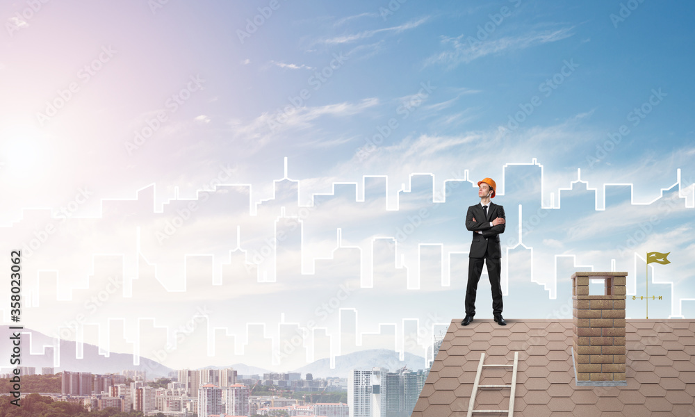 Engineer man standing on roof and looking away. Mixed media Engineer man standing on roof and looking away. Mixed media