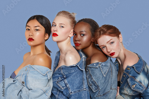 The real beauty exists in every corner of the world and is presented by women of all races. Four beautiful ladies in denim shirts and with different skin and hair colour are posing in a row.