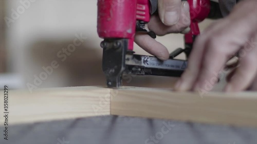 Hydraulic stapling gun staples wooden planks together. Carpenter's shop. Professional carpenter.