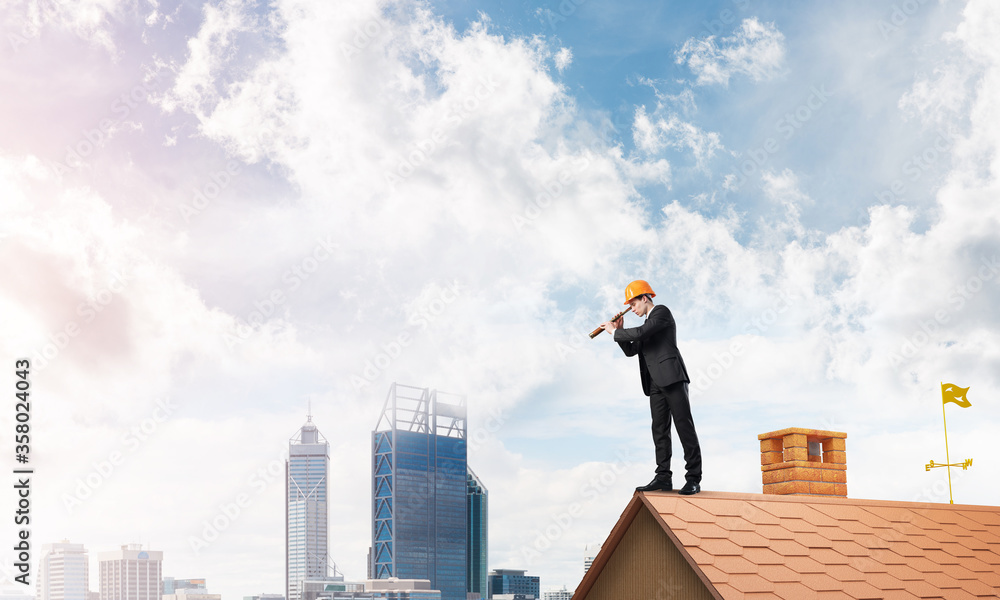 Engineer man standing on roof and looking in spyglass. Mixed media Engineer man standing on roof and looking in spyglass. Mixed media