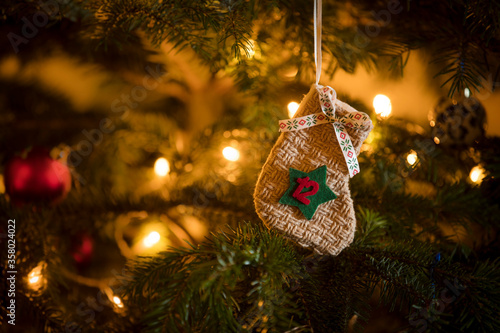 Traditional Advent Calendar Stocking with the date of the twelfth of December hanging on a traditional christmas tree.