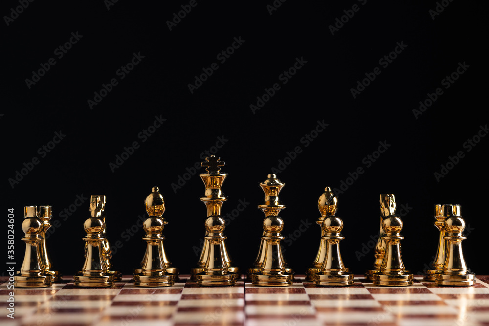 Golden chess figures standing on chessboard Golden chess figures standing on chessboard