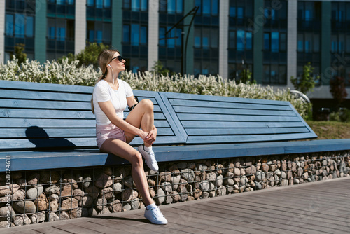 Young fitness woman resting after a hard street workout. Healthy lifestyle and sports, street training, social distancing