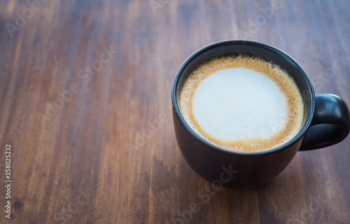 Cup of coffee on brown wooden table at coffee shop. Hot espresso the best start to any morning at cafe with copy space.