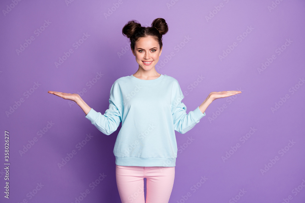 Portrait of positive confident youth girl promoter hold hands present object ads promo wear good look clothes pants isolated over purple color background Portrait of positive confident youth girl promoter hold hands present object ads promo wear good look clothes pants isolated over purple color background
