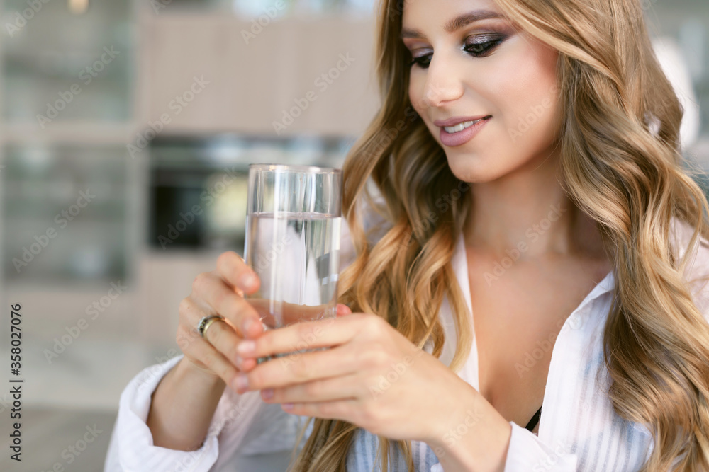 Portrait of a nutritionist. Young happy cheerful attractive woman holds a glass of clean drinking water. Healthy lifestyle concept. Portrait of a nutritionist. Young happy cheerful attractive woman holds a glass of clean drinking water. Healthy lifestyle concept.