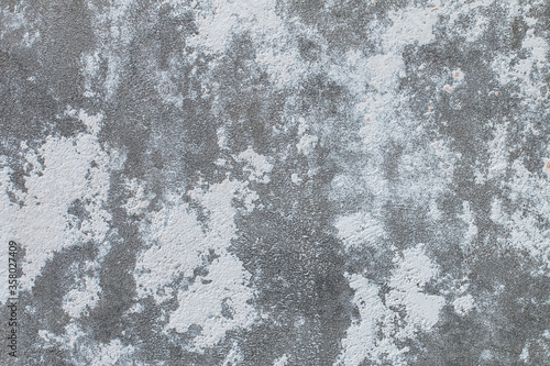 Surface of gray old cement concrete wall with stucco stains. Abstract gray industrial textured background. © Andrey_Maksimov