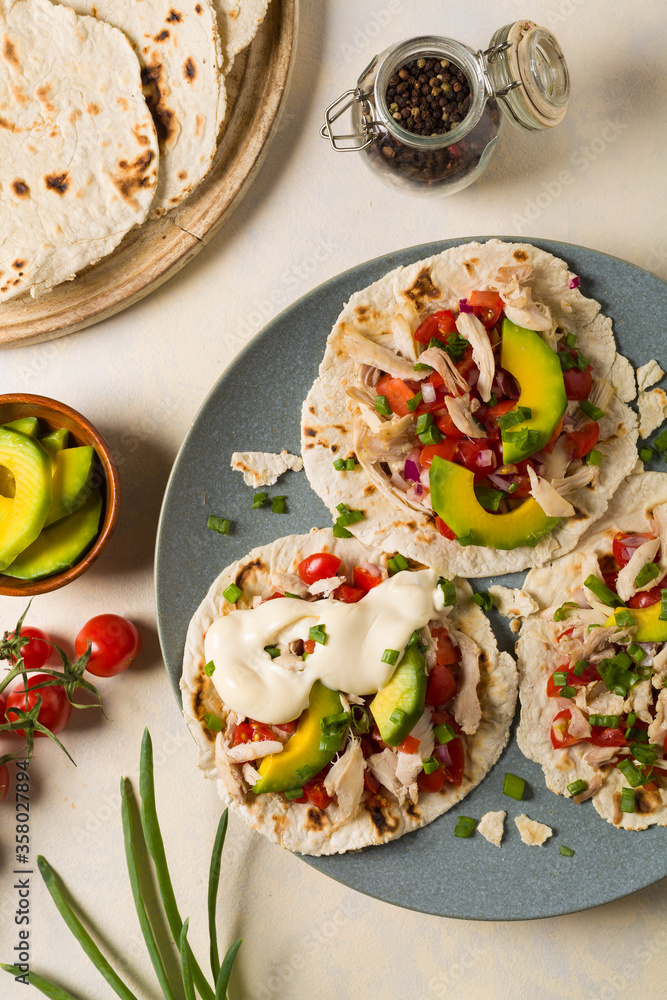 Mini tortillas with tomato salsa, avocado and boiled chicken. Top view. Mini tortillas with tomato salsa, avocado and boiled chicken. Top view.