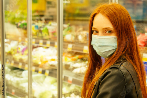 redhaired ginger woman in casual black leather jacket buying products in empty super market second wave