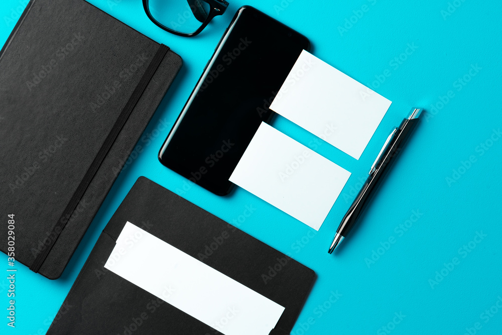 Obraz premium White businesscard with copy space on black notepad