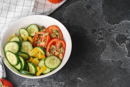 Ceramic bowl of tomato and cucumber salad on table © fotofabrika