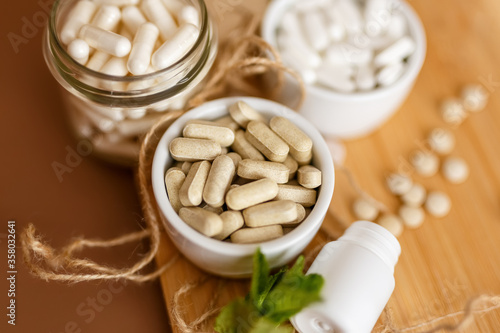 Herbal nutrition supplements and vitamins on brown background. Healthy lifestyle and care about immunity.