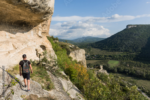 A young man walks along the edge of the mountain