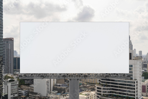 Blank white road billboard with Bangkok cityscape background at day time. Street advertising poster  mock up  3D rendering. Front view. The concept of marketing communication to promote or sell idea.