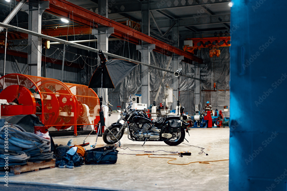Fototapeta premium Motorcycle standing in a dark hangar building