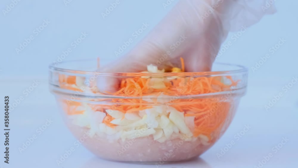 Girl is preparing minced meat. The female hand adds carrots, onions to the cooked minced meat and mixes. Meat dishes Girl is preparing minced meat. The female hand adds carrots, onions to the cooked minced meat and mixes. Meat dishes