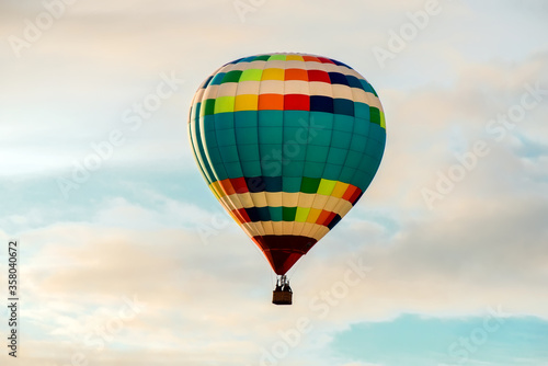 Colorful big hot air balloon flying against the cloudy sky