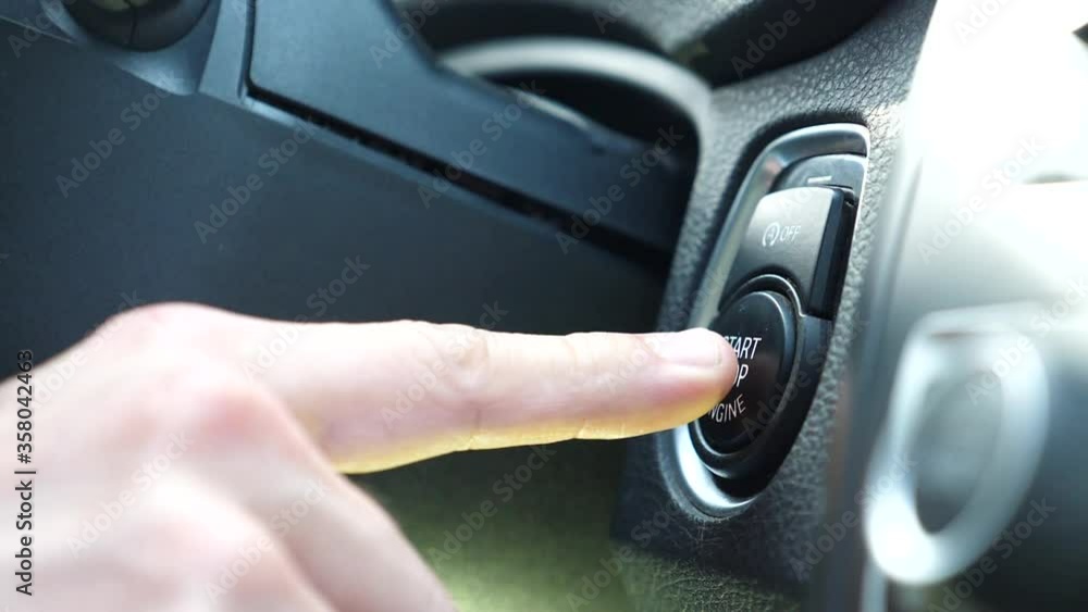 Close up male hand starting car with button. Man hand pushing start stop button in luxury car. Closeup male driver using start button in modern car in slow motion. Close up male hand starting car with button. Man hand pushing start stop button in luxury car. Closeup male driver using start button in modern car in slow motion.