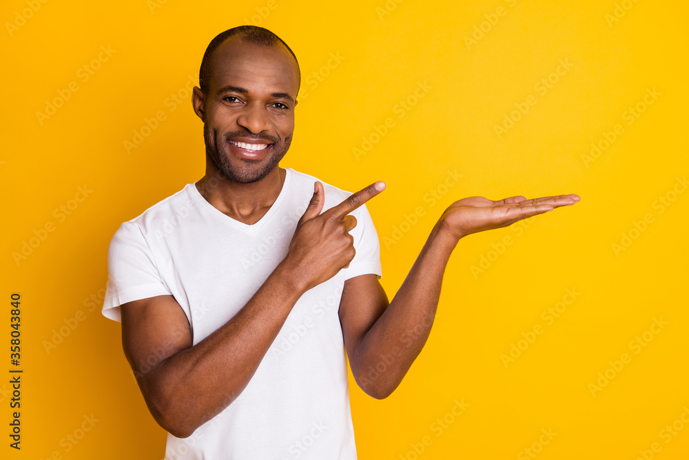 Close-up portrait of his he nice attractive content cheerful cheery guy holding on palm copy space ad decision solution isolated over bright vivid shine vibrant yellow color background