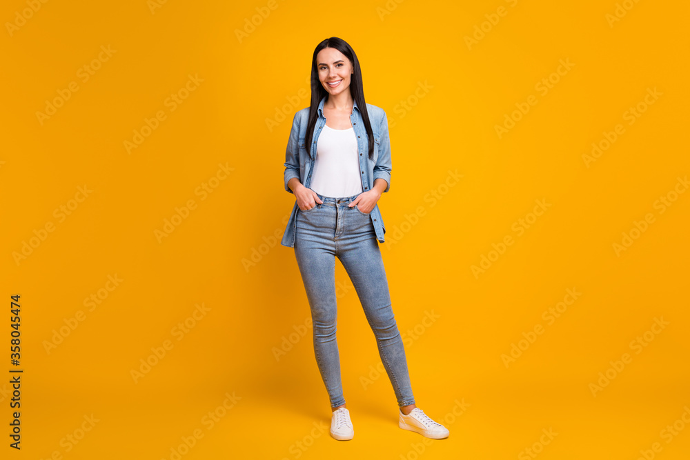 Full length body size view of nice attractive pretty cheerful cheery girl wearing casual clothing posing holding hands in pockets isolated on bright vivid shine vibrant yellow color background Full length body size view of nice attractive pretty cheerful cheery girl wearing casual clothing posing holding hands in pockets isolated on bright vivid shine vibrant yellow color background