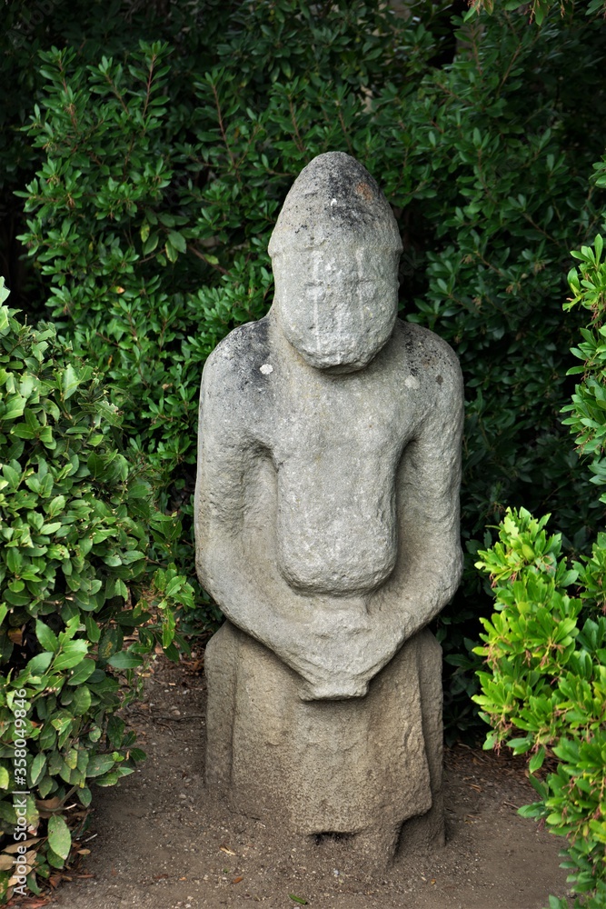 Ancient statue of a Scythian warrior among green spaces.