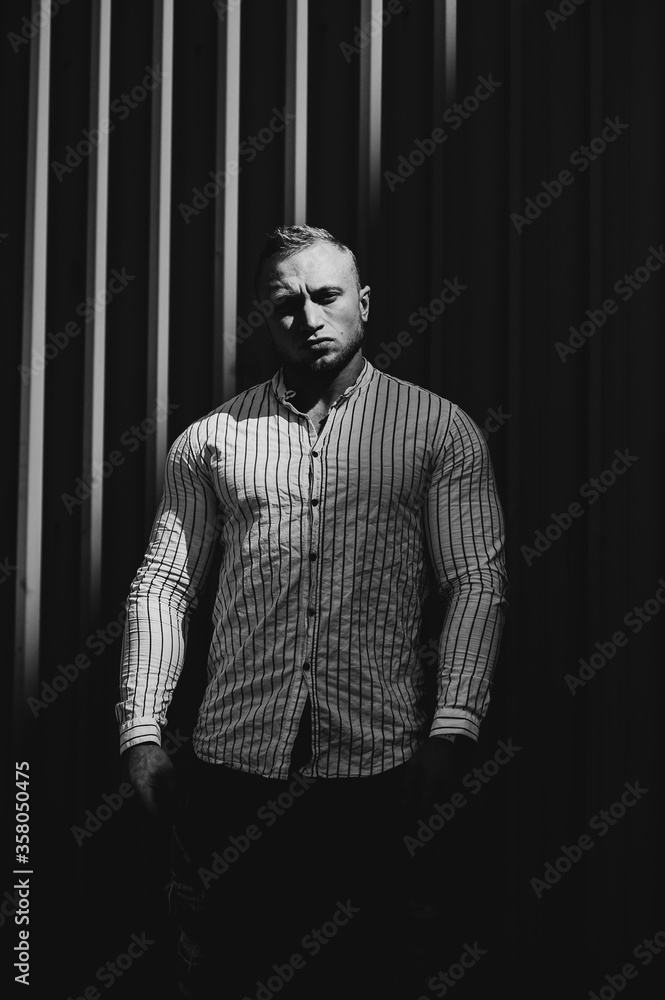 Fototapeta premium Black and white photo. Portrait sportsman in the stripes wall. Contrast theatre art. Men emotion.