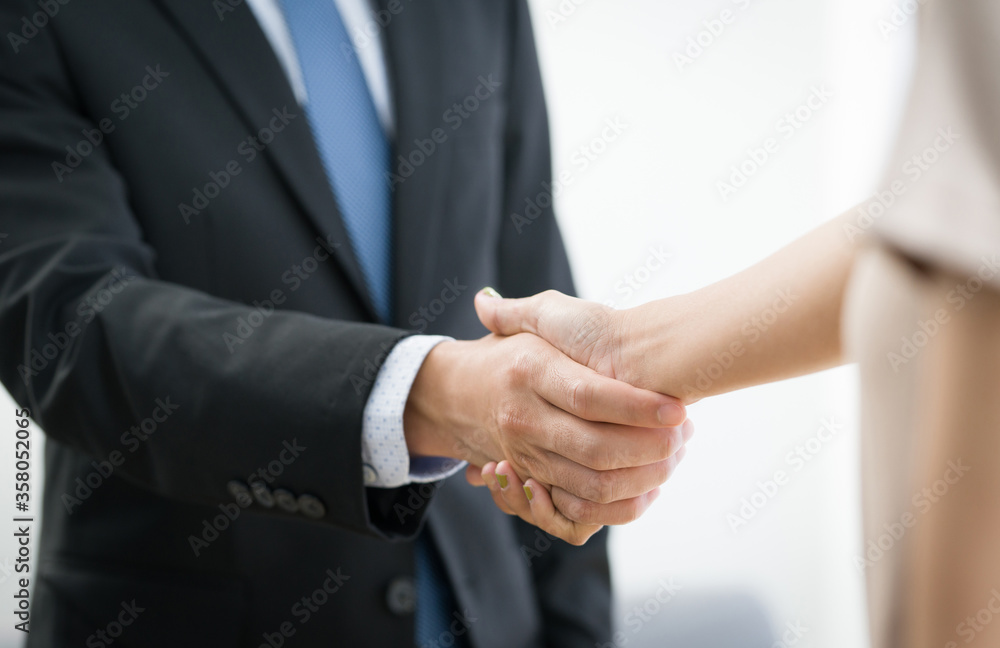 Business partners shaking hands in the modern office