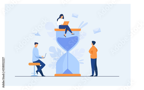Tiny people and huge sand glass flat vector illustration. Cartoon team working together with laptops. Time management and business concept