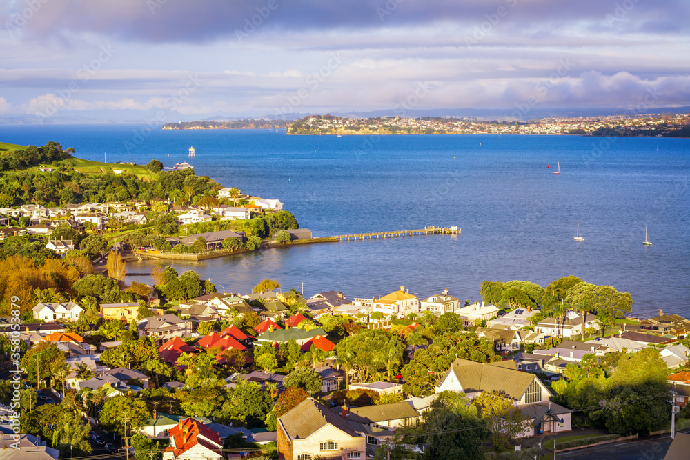 Auckland Harbour and historical suburb of Devonport in warm sunset light.