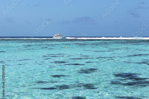 Motor boat sailing in azure waters on Indian ocean near Nalaguraidhoo island. Speed boats used as a main transport to bring people to resorts on Maldives islands. Tropical sunny vacation. Soft focus