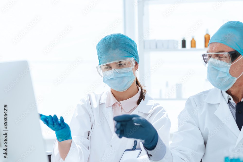 group of scientists using a computer to classify data. group of scientists using a computer to classify data.