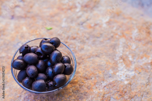 Black olives in a glass.