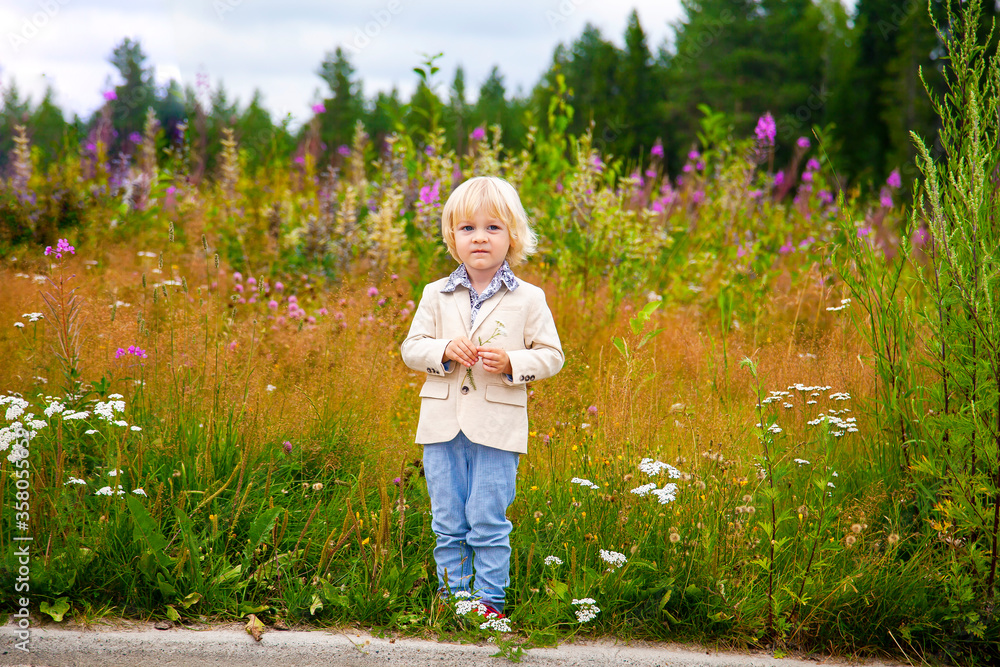 Little blond boy in a gentleman suit on nature. Little blond boy in a gentleman suit on nature.