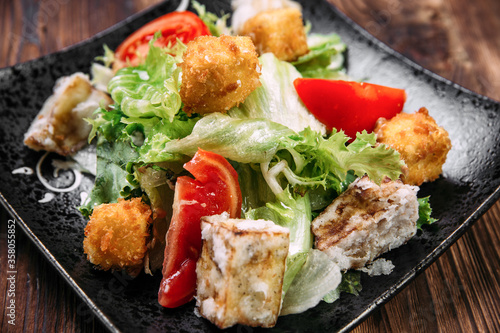 Caesar salad with fried tofu and deep-fried cheese
