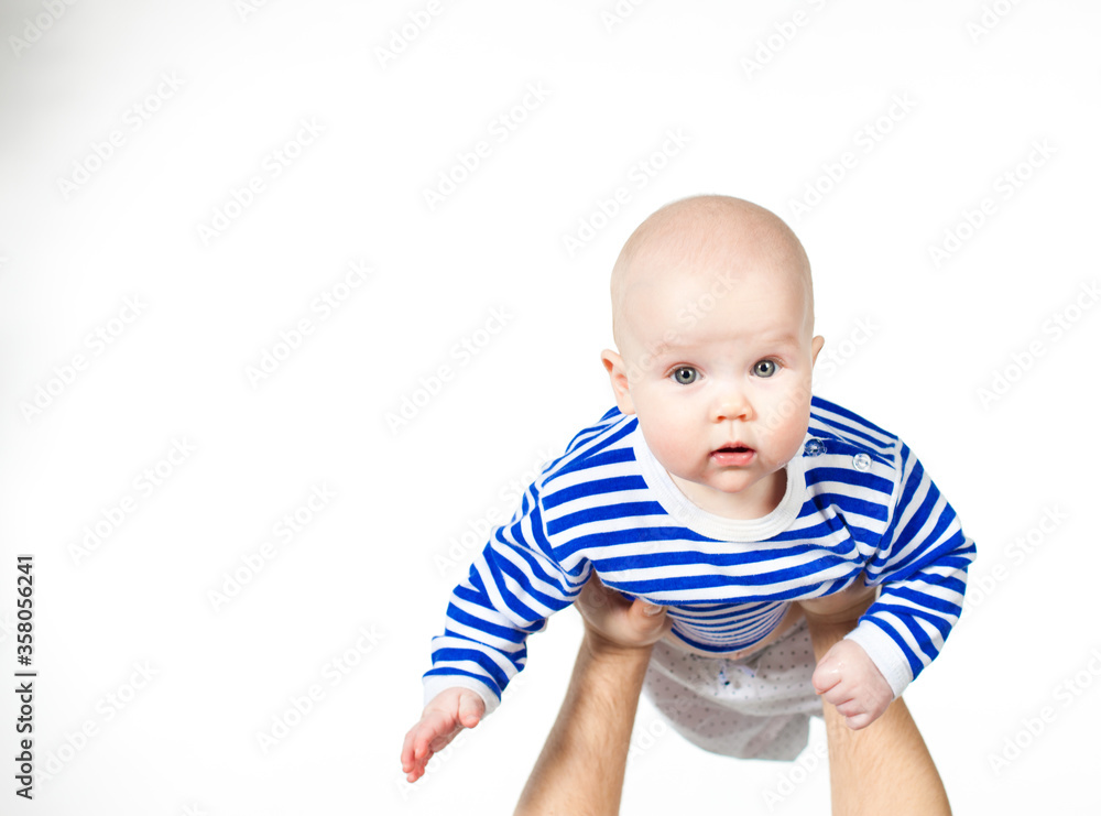 kid in striped top. child is lifted up holding in hands. children's skin care. kid in striped top. child is lifted up holding in hands. children's skin care.