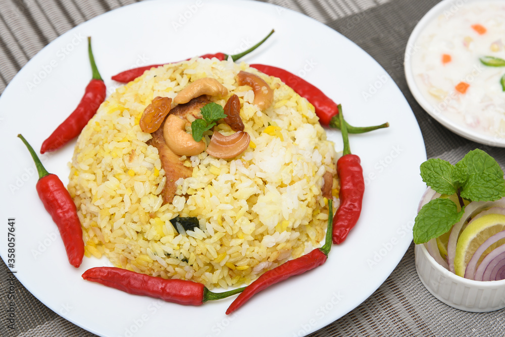 Spicy and delicious chicken biryani in traditional clay pot. Malabar biryani or Hydrabadi chicken biryani, Dum Biriyani, Chicken pulao basmati rice, herbs, raitha for Ramadan Kareem, Eid Spicy and delicious chicken biryani in traditional clay pot. Malabar biryani or Hydrabadi chicken biryani, Dum Biriyani, Chicken pulao basmati rice, herbs, raitha for Ramadan Kareem, Eid