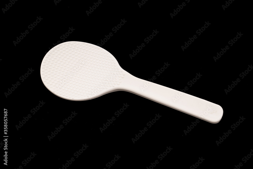 White Plastic ladle on black background White Plastic ladle on black background